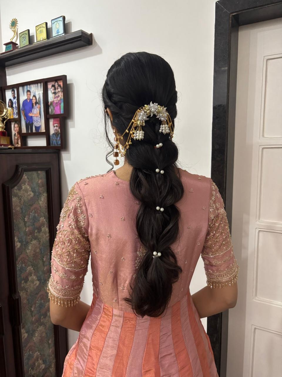 Long braided hairstyle with pearl and gold accessories